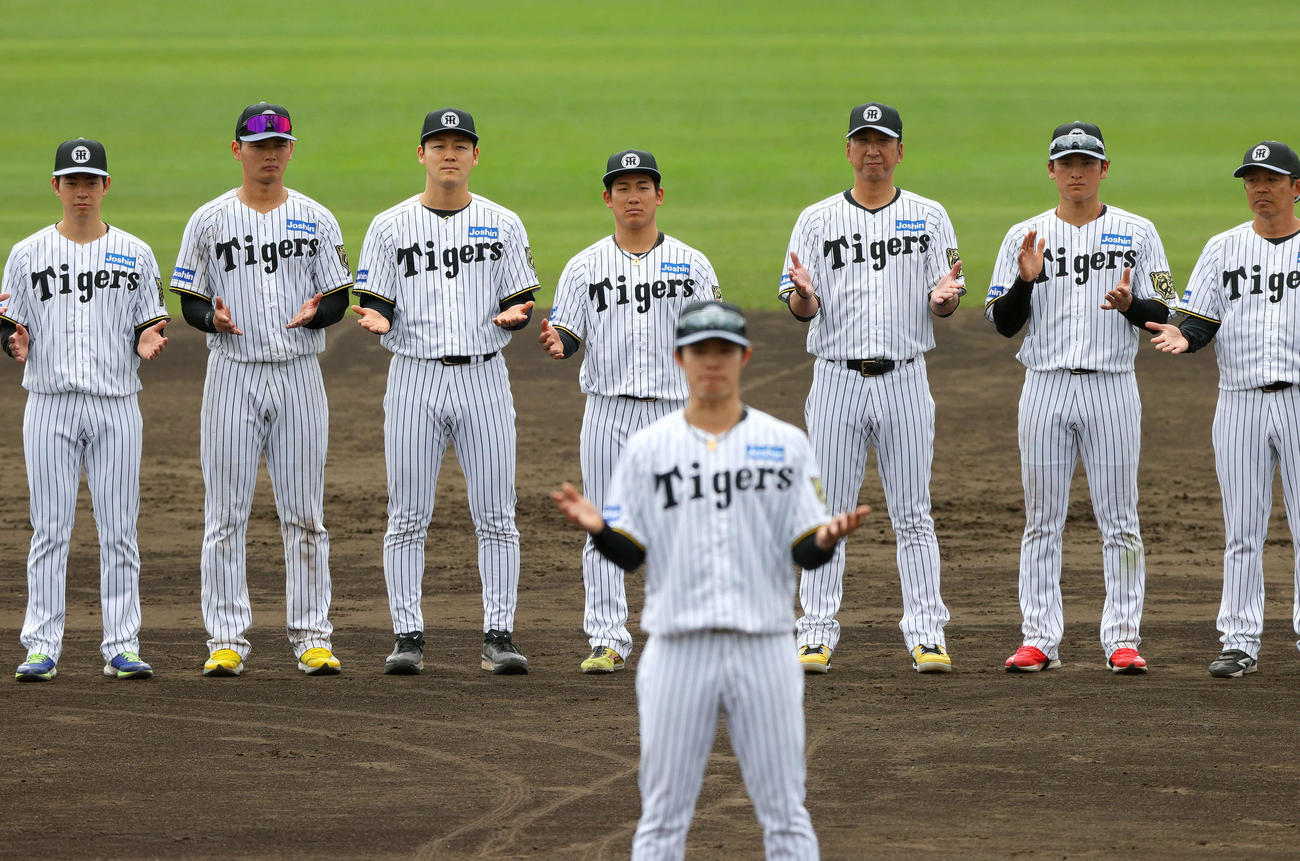 一丁締めで宜野座の春季キャンプを打ち上げる、左から下村、町田、木下、伊原、藤川監督、高寺、藤本総合コーチ（撮影・上山淳一）