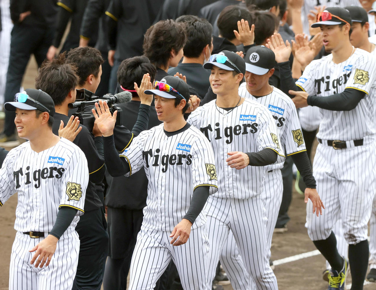 春季キャンプを打ち上げ、スタッフらとタッチをかわす、左から阪神糸原、近本、木浪、植田、佐藤輝ら（撮影・上山淳一）
