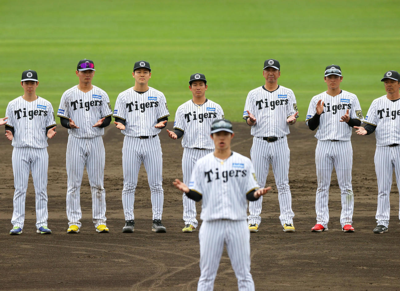 一丁締めで宜野座の春季キャンプを打ち上げる、左から下村、町田、木下、伊原、藤川監督、高寺、藤本総合コーチ。手前は中野（撮影・上山淳一）