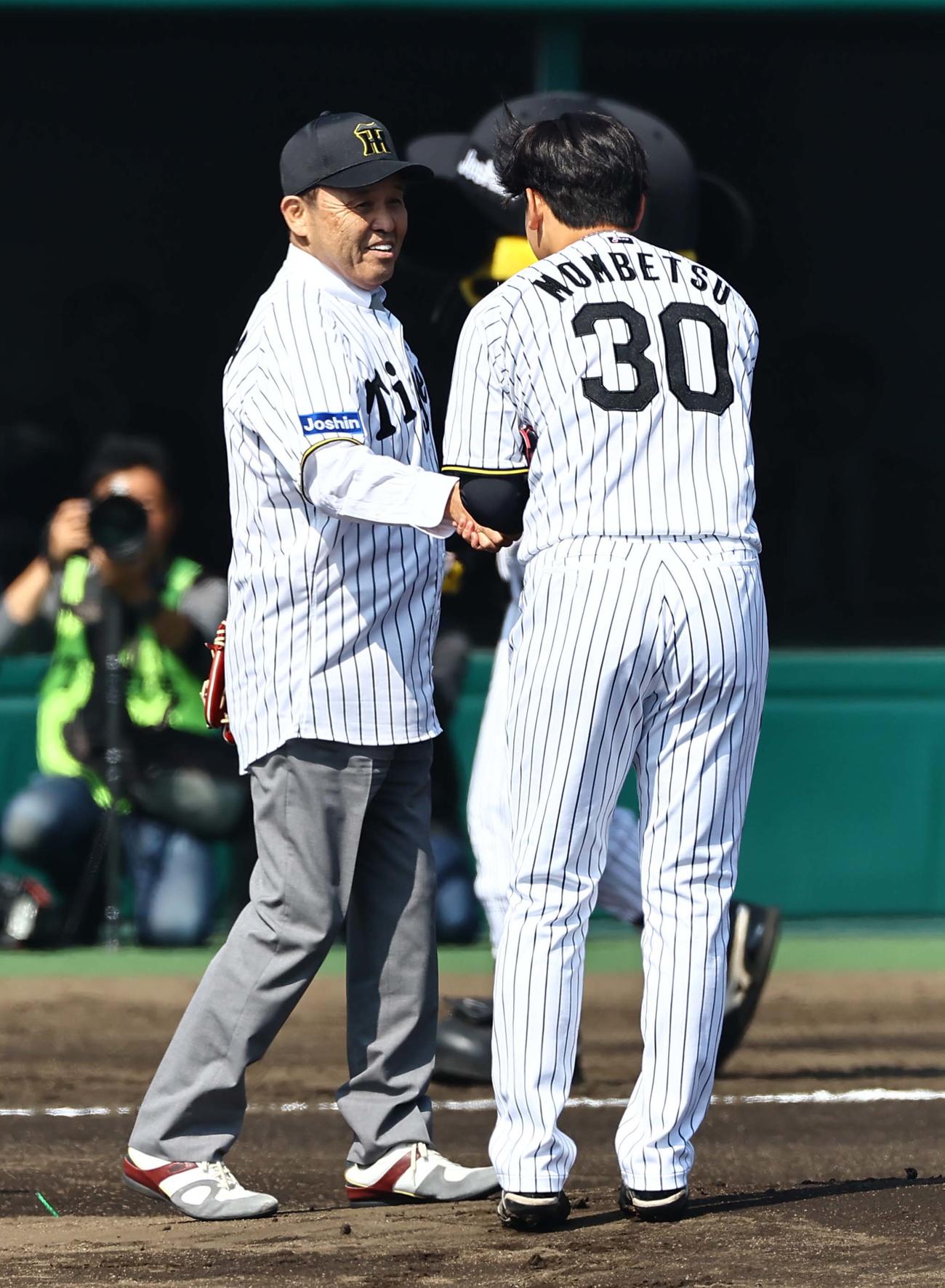 阪神対広島　始球式を務めた岡田オーナー付顧問（左）は先発門別と握手を交わす（撮影・上田博志）