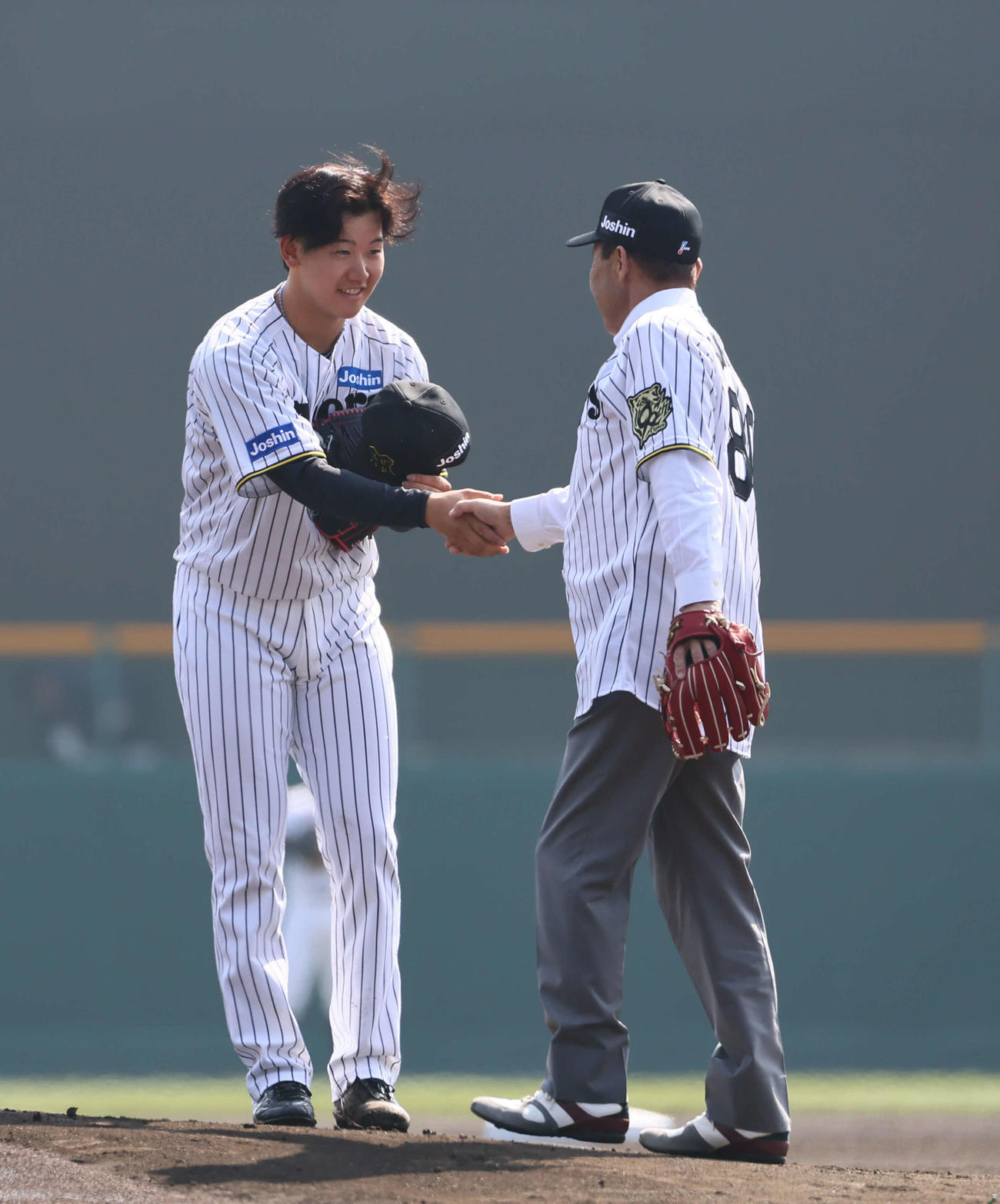 阪神対広島　始球式を終え門別と握手を交わす阪神岡田オーナー付顧問（撮影・藤尾明華）