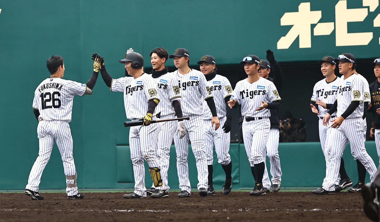阪神対広島　9回裏阪神1死一、二塁、サヨナラ打を放った福島（左）をハイタッチで出迎える阪神ナイン（撮影・上田博志）