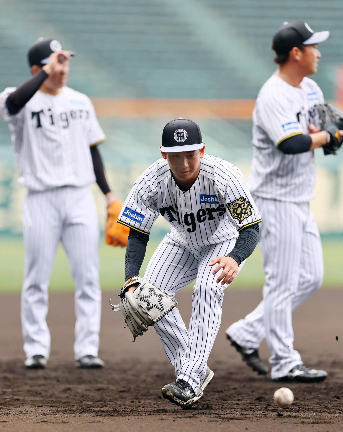 ノックを受ける阪神伊原。右は桐敷、左は石井（撮影・藤尾明華）