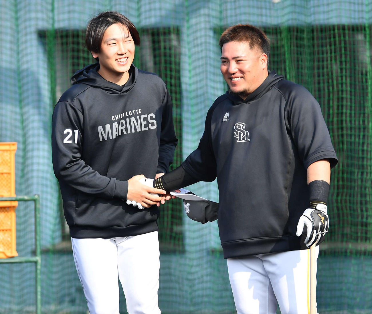 ソフトバンク対ロッテ　試合前、ソフトバンク山川（右）と笑顔で握手を交わすロッテ石川柊（撮影・岩下翔太）