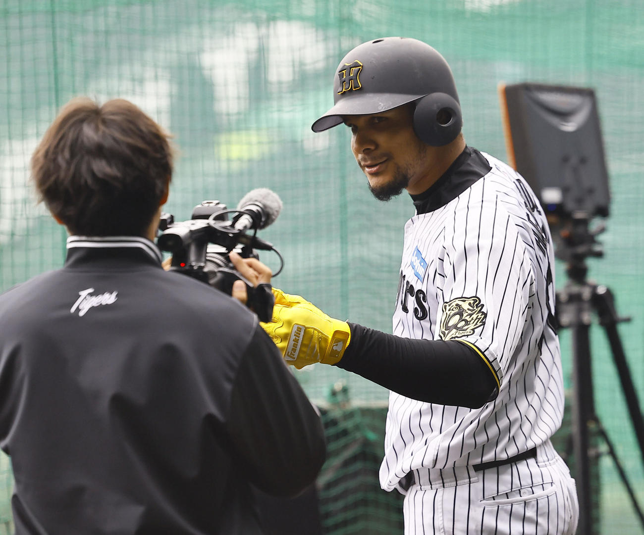 打撃練習中に誕生日を祝う歌が流れ、カメラに向かって笑顔を見せるヘルナンデス（撮影・藤尾明華）