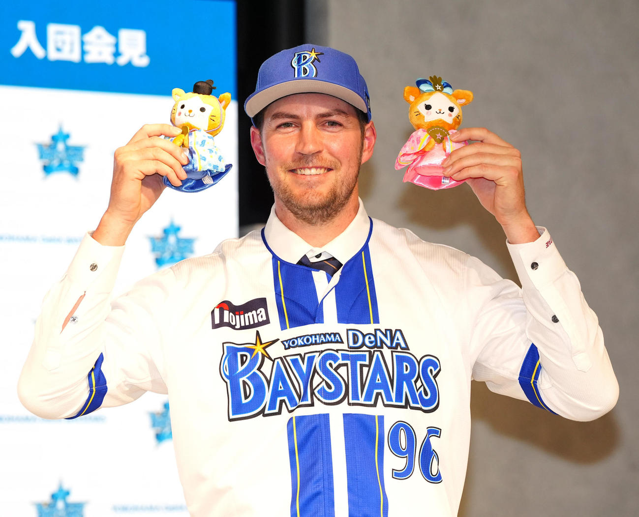 入団会見に臨み、ひな祭り使用のマスコット人形を手にするDeNAバウアー（撮影・江口和貴）