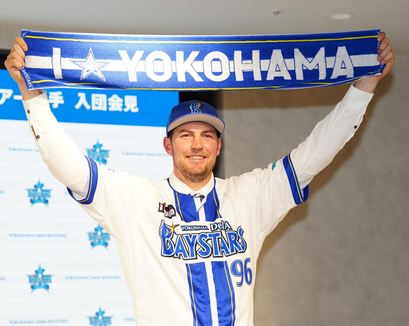 入団会見に臨み、タオルを掲げるDeNAバウアー（撮影・江口和貴）
