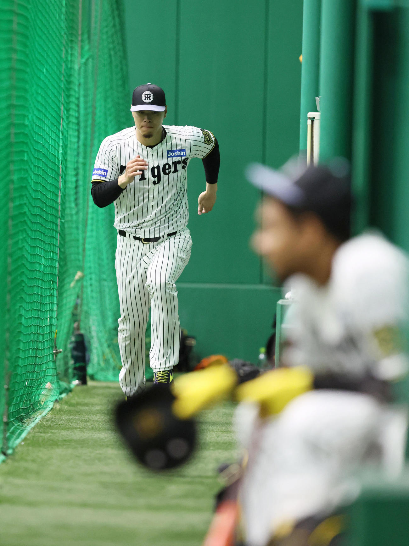佐藤輝は室内のネットで仕切られた細い通路でダッシュして次の練習メニューに移行する（撮影・加藤哉）