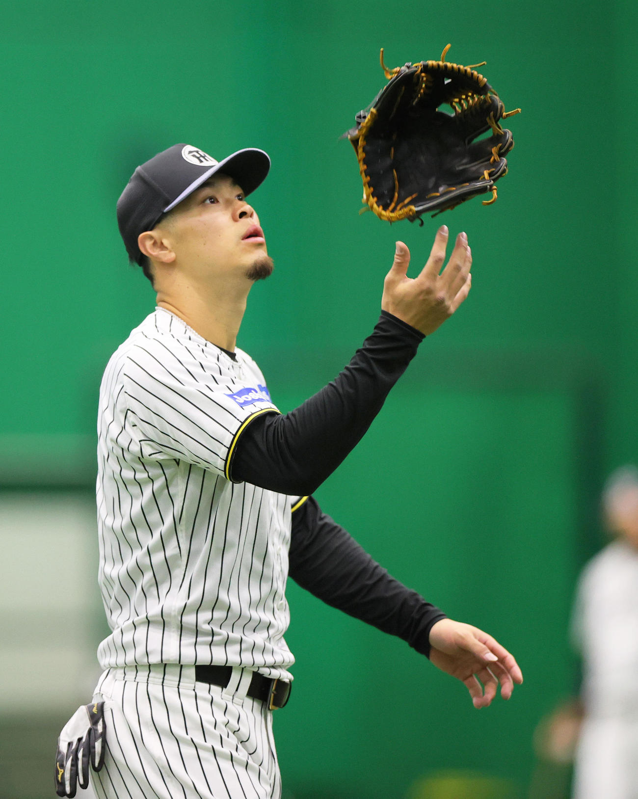 阪神佐藤輝は練習の合間にグラブを宙に浮かせる（撮影・上山淳一）