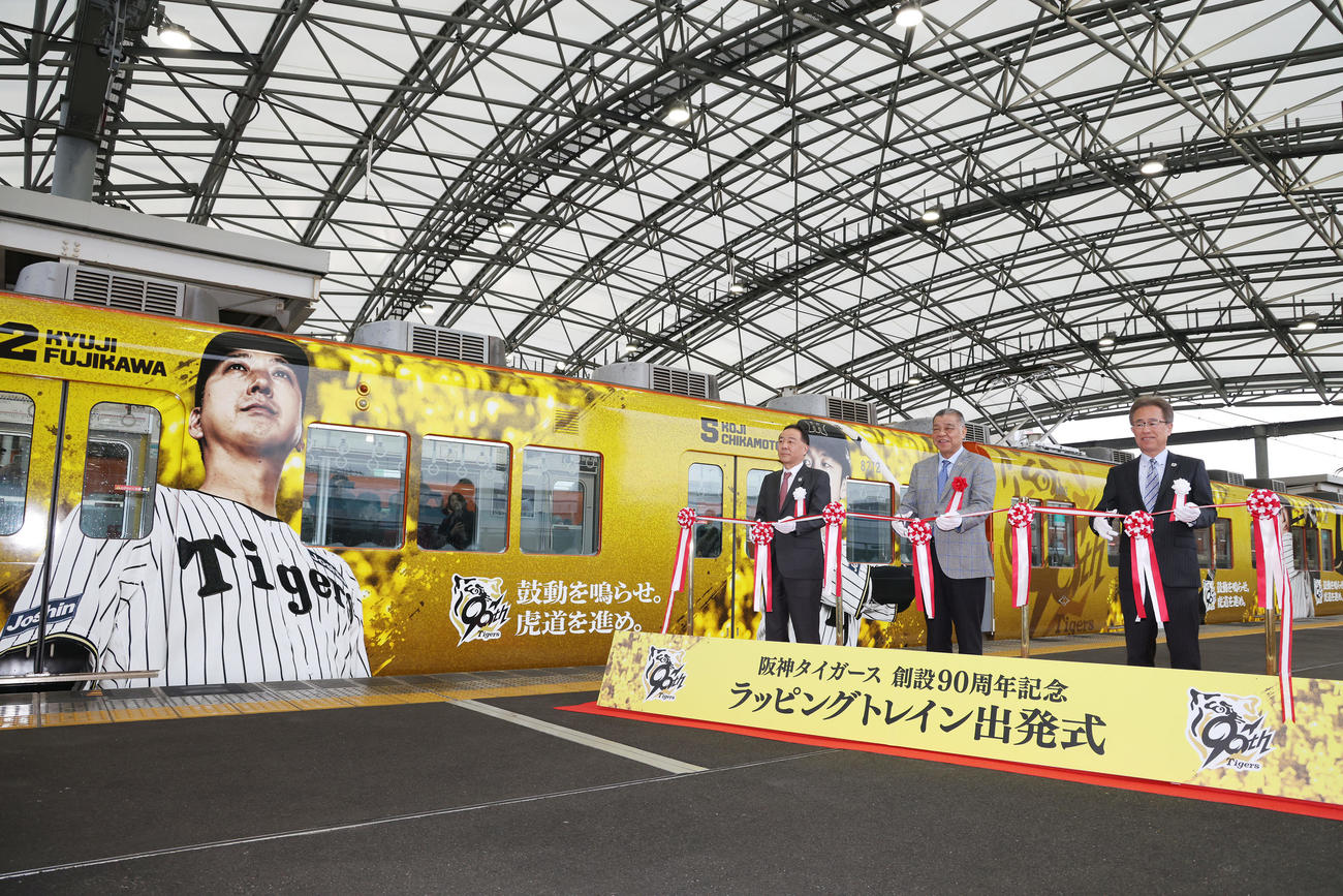「阪神タイガース創設90周年記念　ラッピングトレイン出発式」でテープカットを行う、右から阪神粟井球団社長、掛布OB会長、阪神電鉄の原田都市交通事業本部長（撮影・前田充）