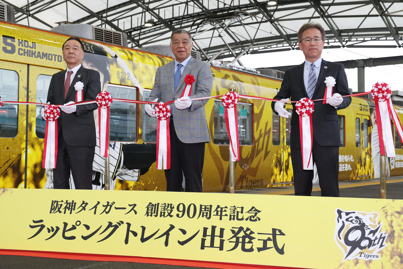 「阪神タイガース創設90周年記念　ラッピングトレイン出発式」でテープカットを行う阪神掛布OB会長（中央）と粟井球団社長。左は阪神電鉄の原田都市交通事業本部長（撮影・前田充）