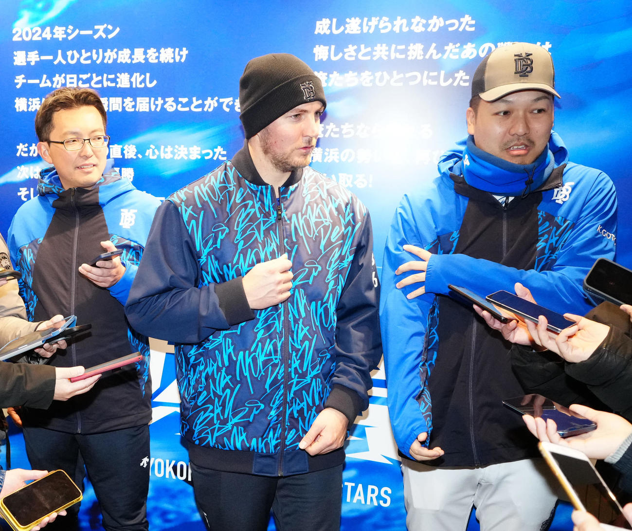 DeNA対広島　練習後、取材に応じ、上着のファスナーを上げるしぐさを見せるDeNAバウアー（中央）（撮影・江口和貴）