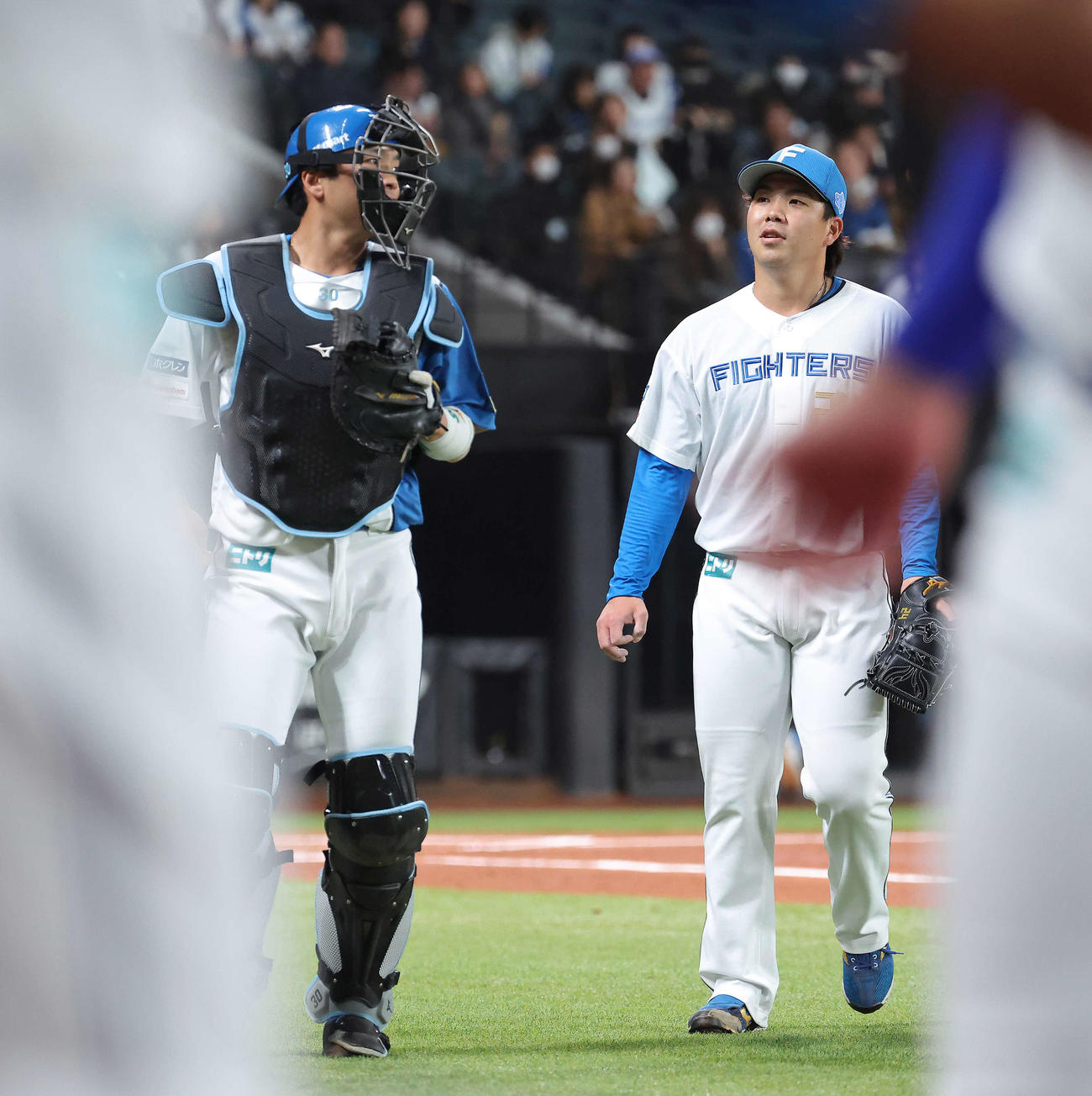 日本ハム対西武　1回表を抑え、言葉を交わしながらベンチに戻る郡司（左）と金村（撮影・河田真司）