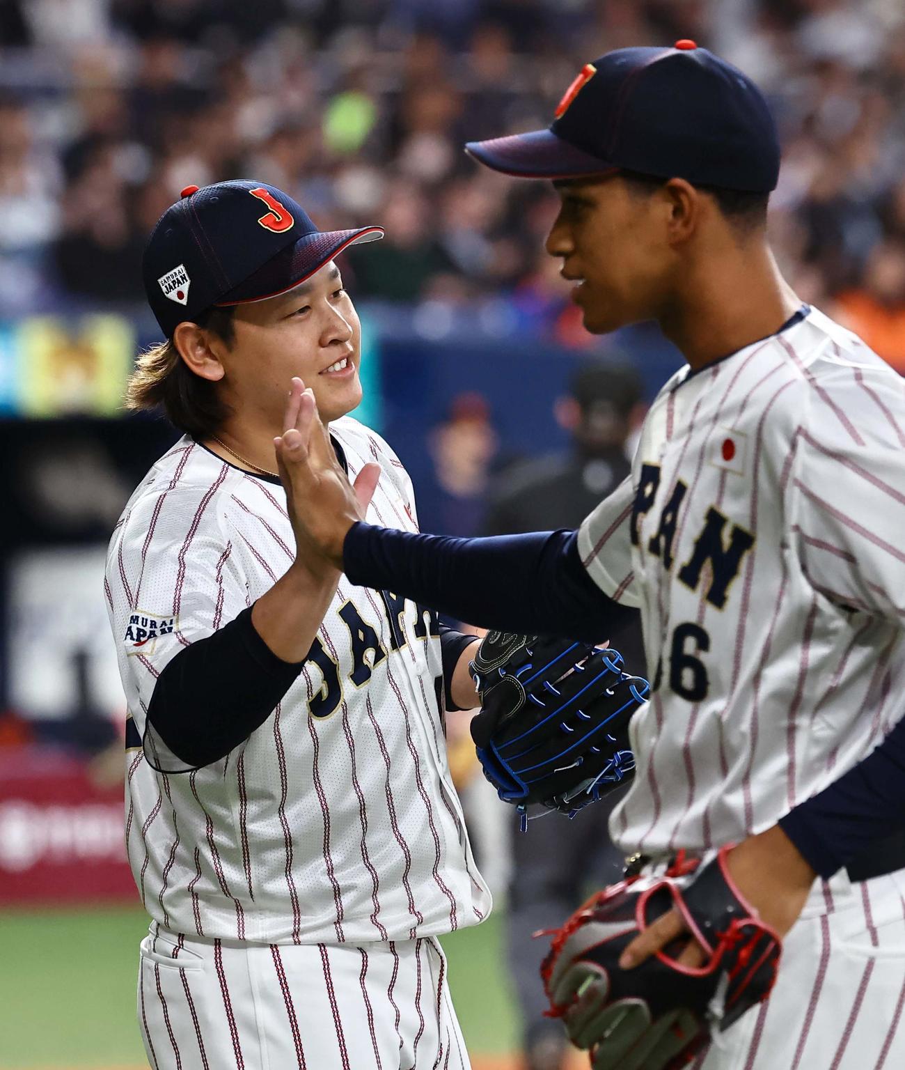 日本対オランダ　好投する宮城（左）は万波と笑顔でハイタッチする（撮影・上田博志）