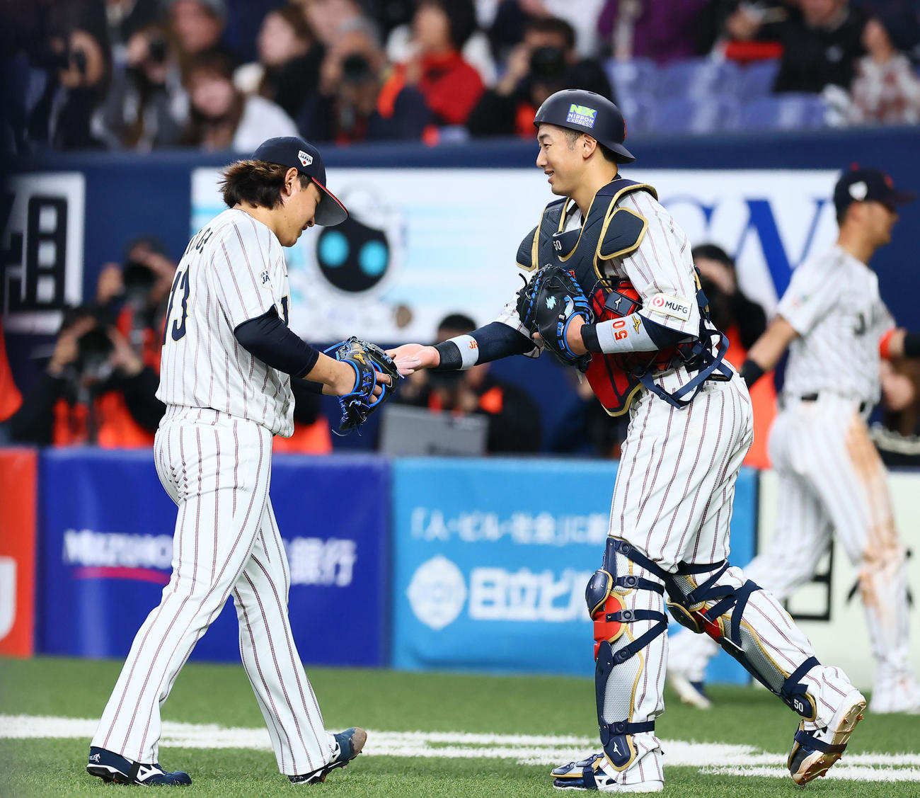 日本対オランダ　3回無安打無失点の好投を見せ、山本（右）とタッチを交わす宮城（撮影・藤尾明華）
