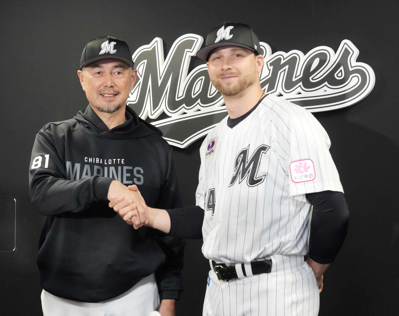 入団会見に臨み吉井理人監督（左）と握手するロッテ新外国人のボス投手（撮影・小沢裕）