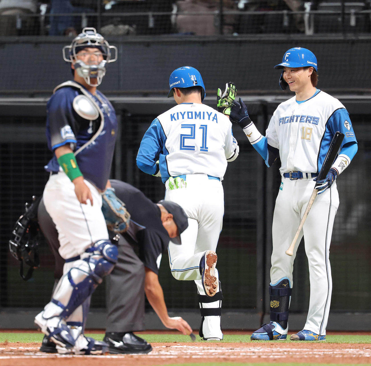 日本ハム対西武　3回裏日本ハム2死、右越えソロ本塁打で生還する清宮幸（中央）を迎える山崎（撮影・河田真司）