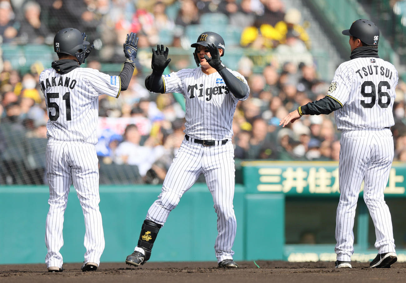 オープン戦・阪神対DeNA 1回裏阪神1死一塁、前川（中央）は先制の右越え2点本塁打を放ち出迎えの一走中野とハイタッチする。右は筒井外野守備兼走塁チーフコーチ（撮影・上山淳一）