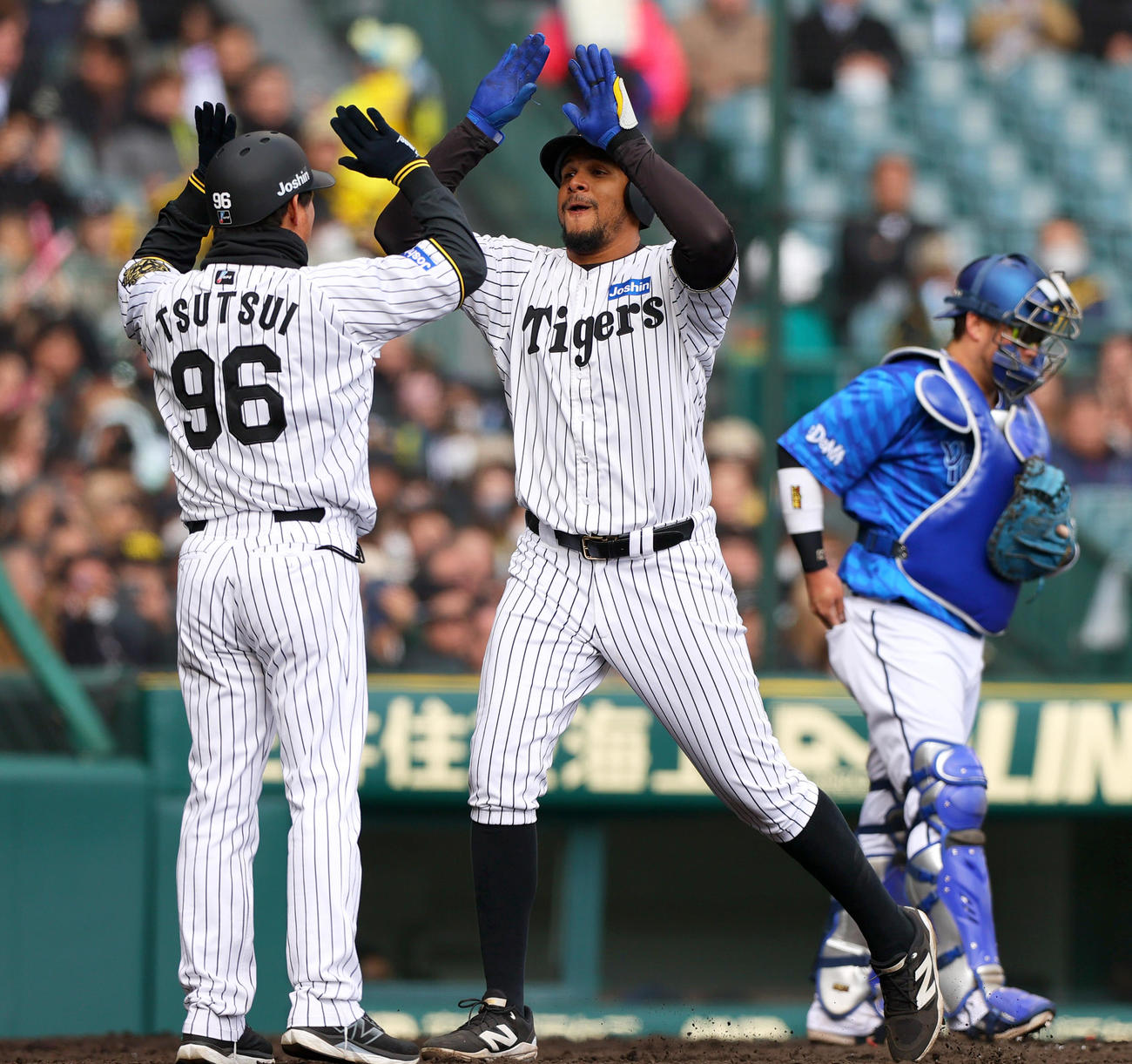 オープン戦・阪神対DeNA 5回裏阪神1死、ヘルナンデス（中央）は左中間越えソロ本塁打を放ち生還し筒井外野守備兼走塁チーフコーチとハイタッチする（撮影・上山淳一）