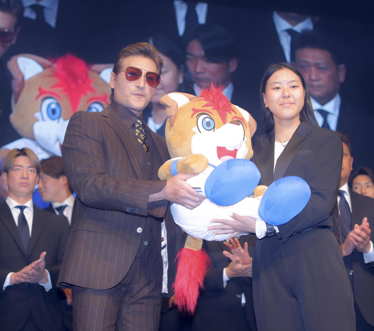 日本ハム新庄監督（左）からフレップ人形を受け取る東京・パリ五輪スケートボード女子パーク銀メダリストの開（撮影・河田真司）