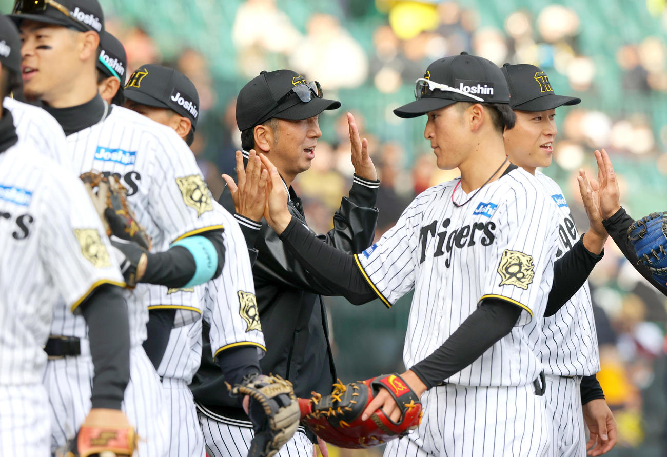 オープン戦・阪神対DeNA　阪神藤川監督（中央）はDeNAに勝利しナインとタッチをかわす（撮影・上山淳一）