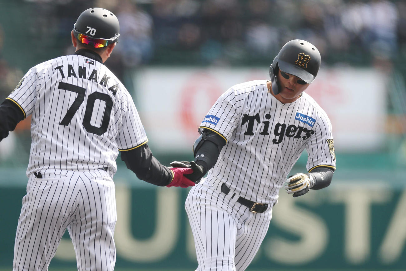 阪神対DeNA 1回裏阪神1死一塁、先制の右越え2点本塁打を放ち、田中コーチ（左）とタッチを交わす前川（撮影・前田充）