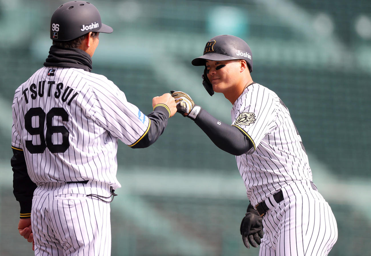 オープン戦・阪神対DeNA 3回裏阪神無死一、二塁、前川（右）は左前打を放ち笑顔で筒井外野守備兼走塁チーフコーチとタッチをかわす（撮影・上山淳一）