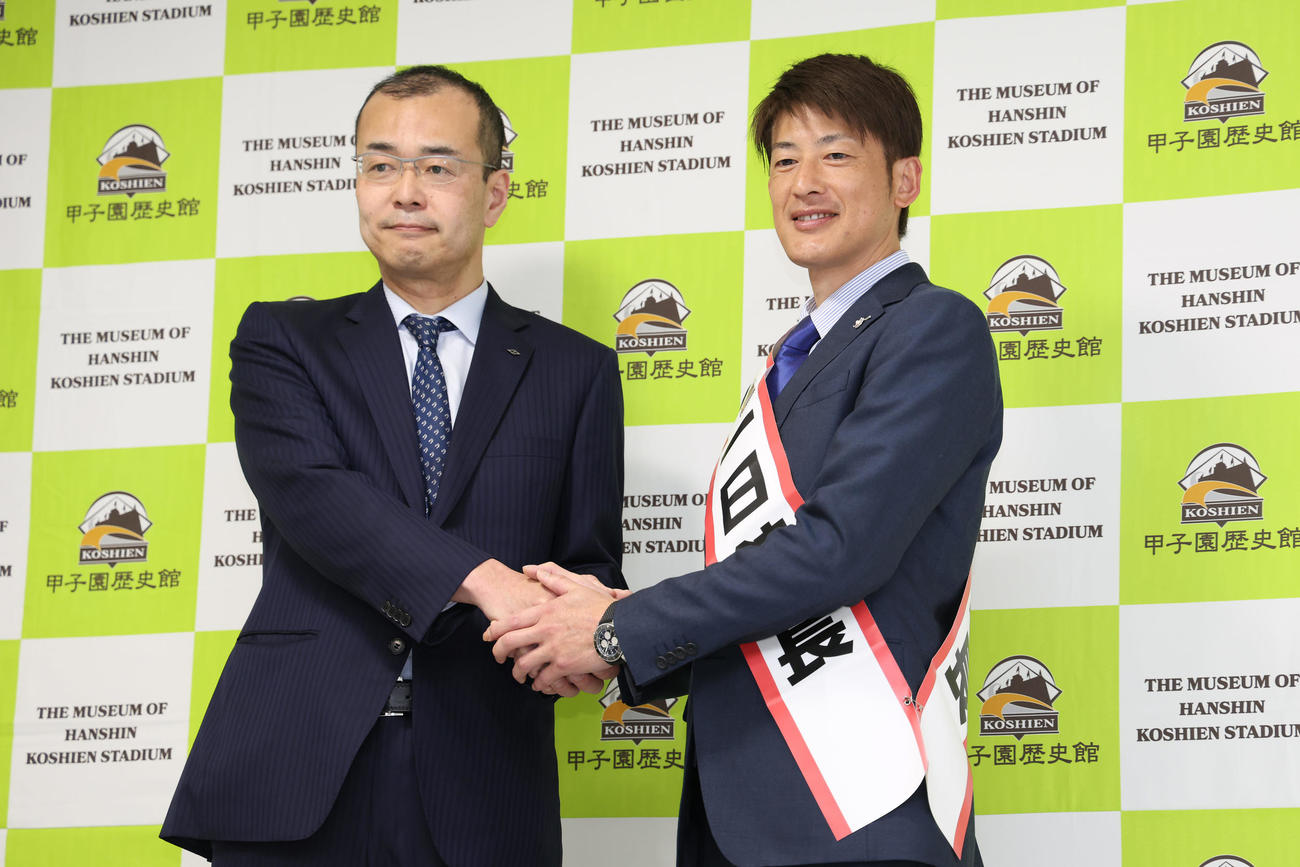 甲子園歴史館の一日館長に任命され、向井球場長（左）と握手を交わす能見氏（撮影・前田充）