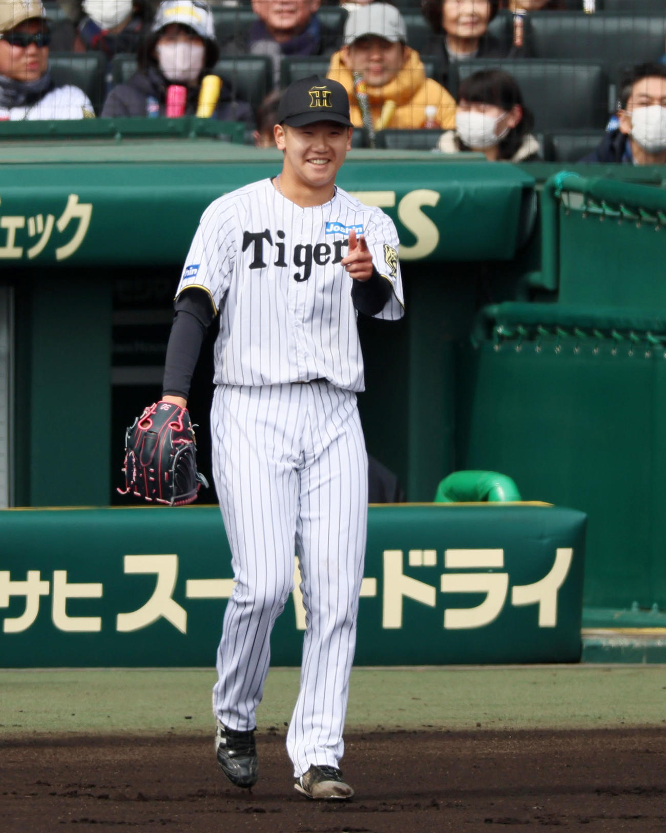 阪神対DeNA 1回表を無失点ピッチングで終えベンチ前で好守を見せた小幡を指さす笑顔の門別（撮影・加藤哉）
