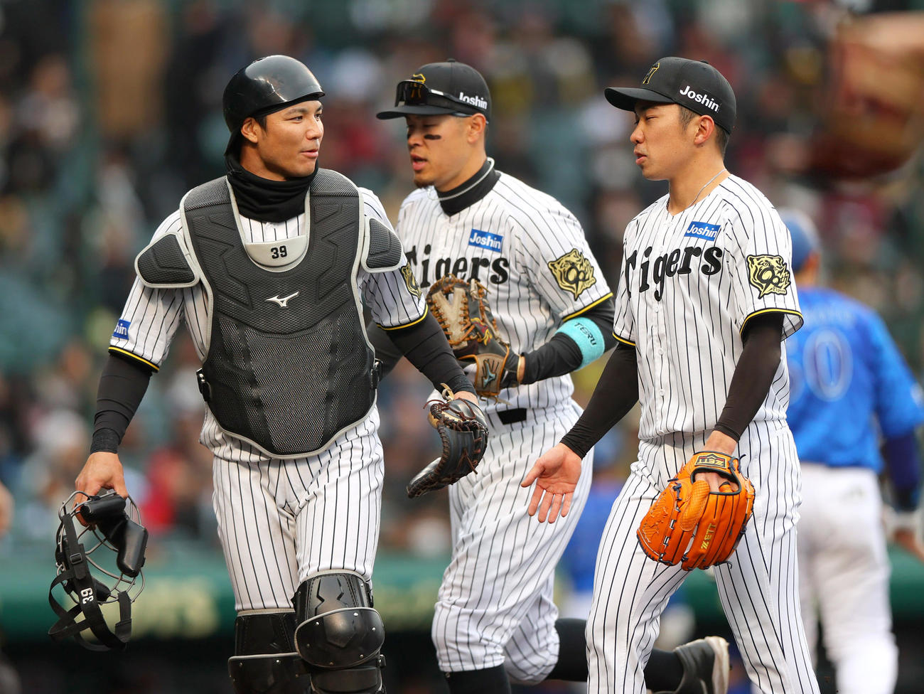 オープン戦・阪神対DeNA 6回表に登板の石井（右）は無失点に終え捕手栄枝と言葉をかわしベンチに引き揚げる。中央は佐藤輝（撮影・上山淳一）
