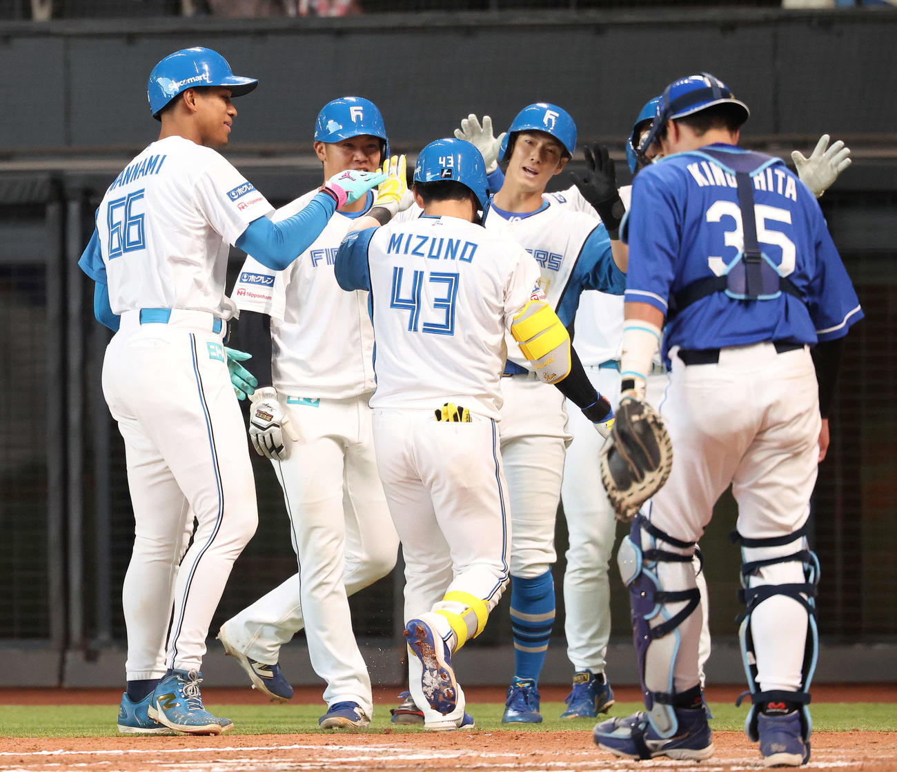日本ハム対中日　6回裏日本ハム2死満塁、右越え逆転満塁本塁打で生還し、チームメートに迎えられる水野（中央）（撮影・河田真司）
