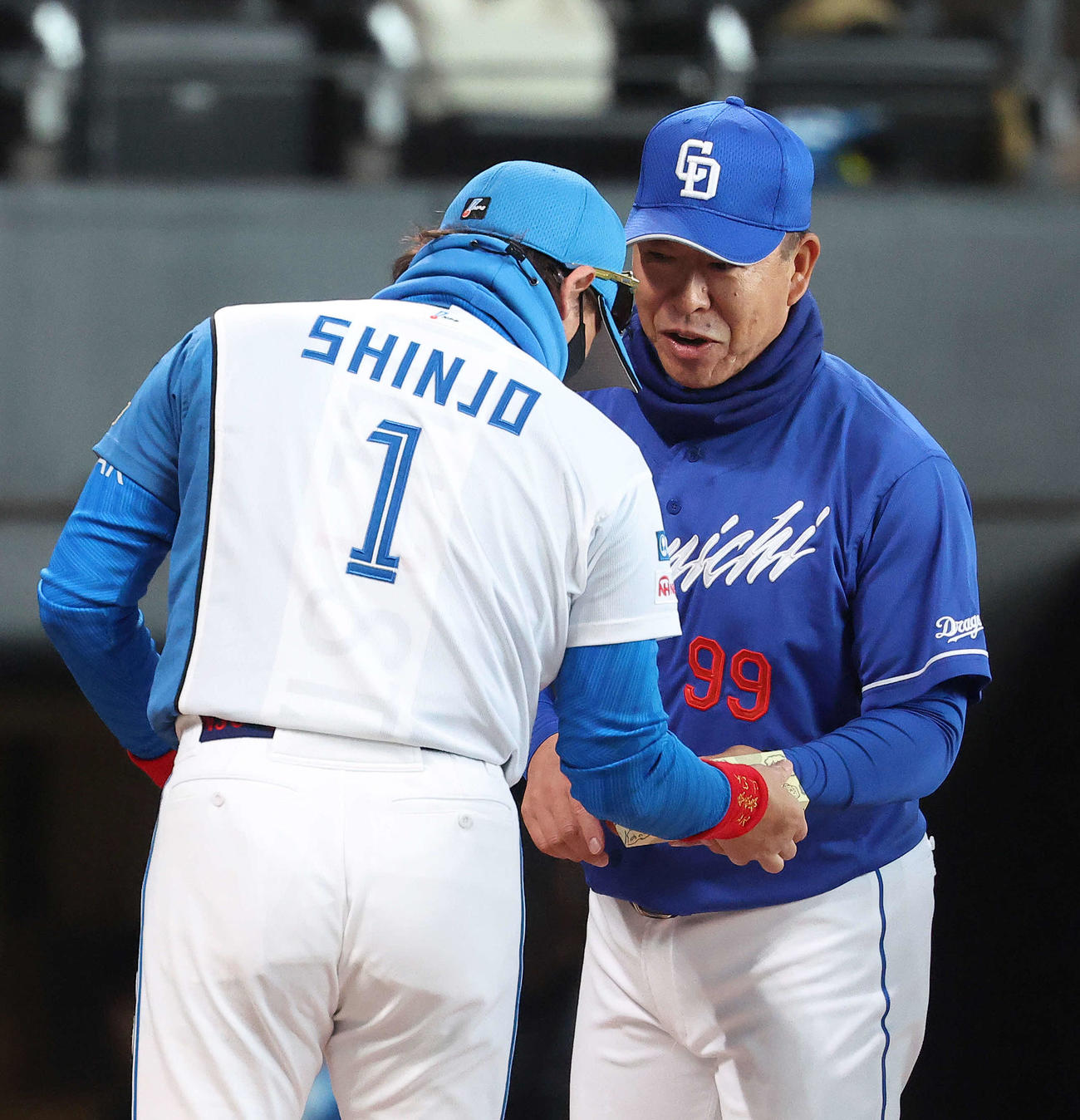 日本ハム対中日　開始前、メンバー表交換で中日井上監督（右）から「きよめぱん」を受け取る日本ハム新庄監督（撮影・河田真司）