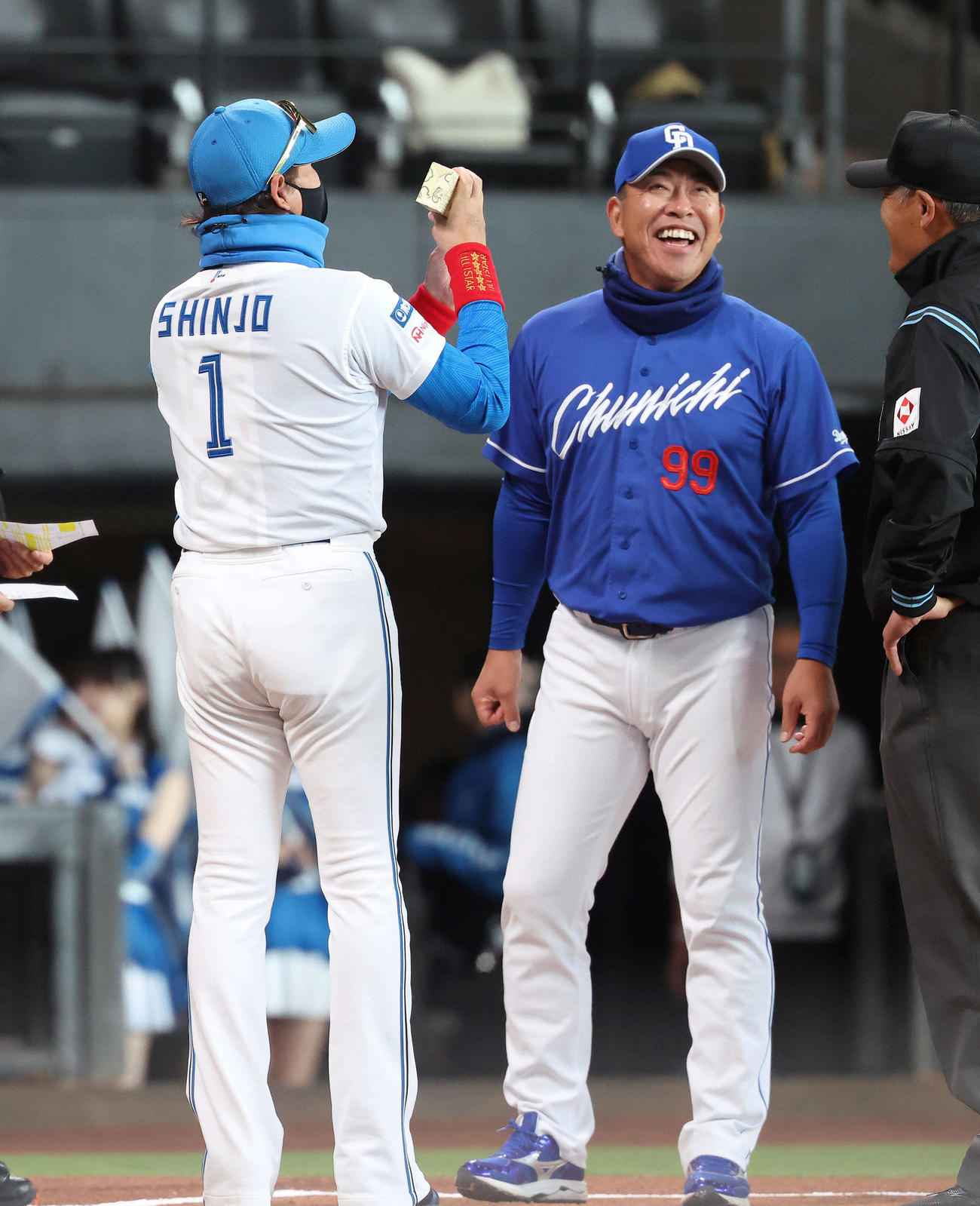 日本ハム対中日　開始前、メンバー表交換で中日井上監督（右）から「きよめぱん」を受け取る日本ハム新庄監督（撮影・河田真司）