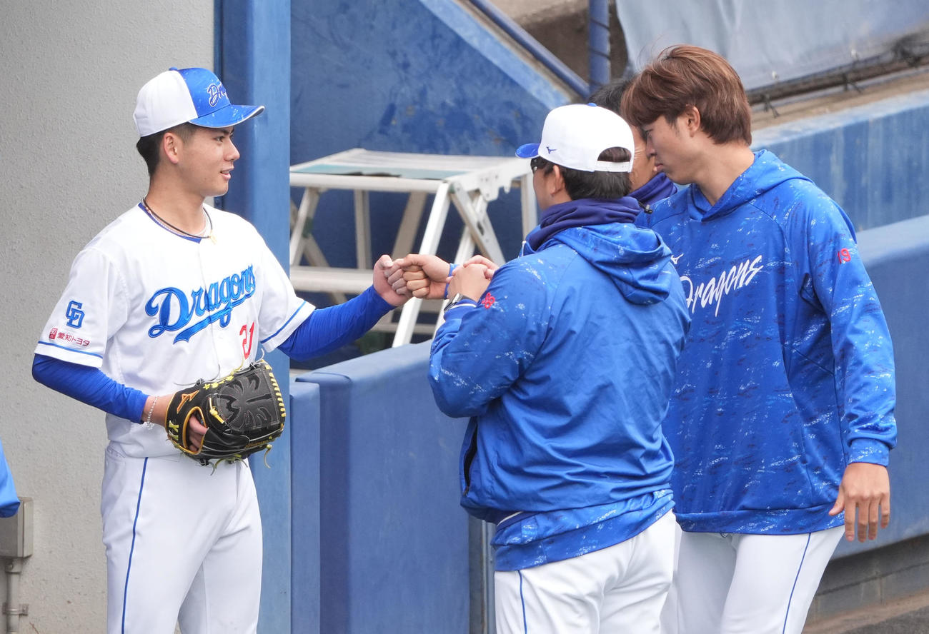 シート打撃練習に登板後、高橋宏とタッチを交わす金丸（左）（25年3月8日撮影）