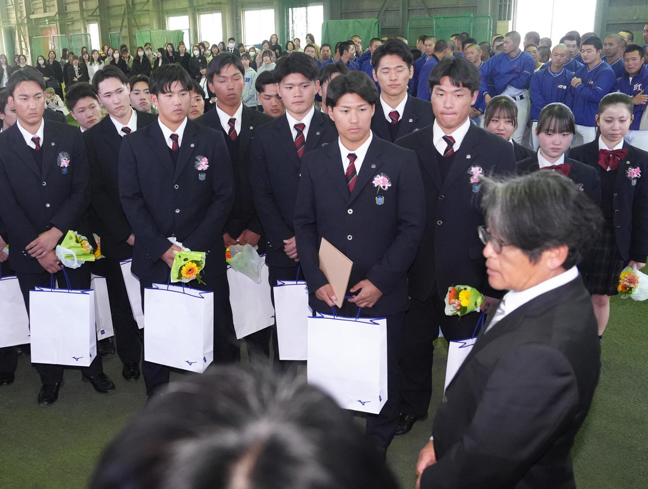 花咲徳栄高校の卒業式を終え、野球部岩井監督（手前右）の話を聞く巨人石塚（左から3人目）とオリックス上原（同6人目）（撮影・足立雅史）