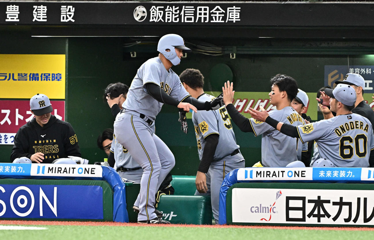 西武対阪神　9回表阪神2死、遊撃内野安打を放った前川（手前）は交代しチームメートとタッチをかわす（撮影・滝沢徹郎）