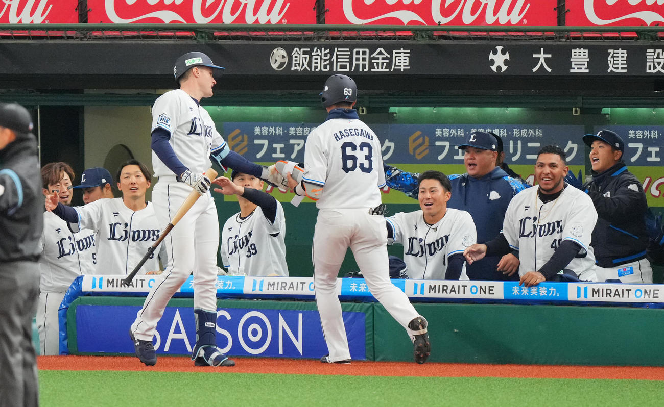 西武対阪神　7回裏西武2死一、二塁、先制の適時打を放ち交代した長谷川（中央）を笑顔で迎えるナイン（撮影・垰建太）