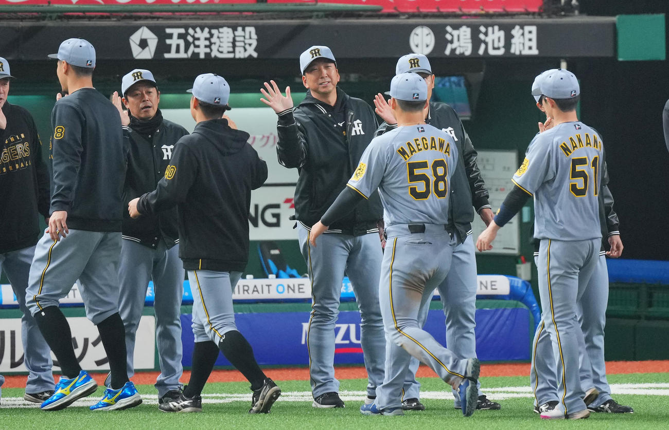 西武対阪神　西武に勝利しナインと笑顔でタッチを交わす阪神藤川監督（中央）（撮影・垰建太）