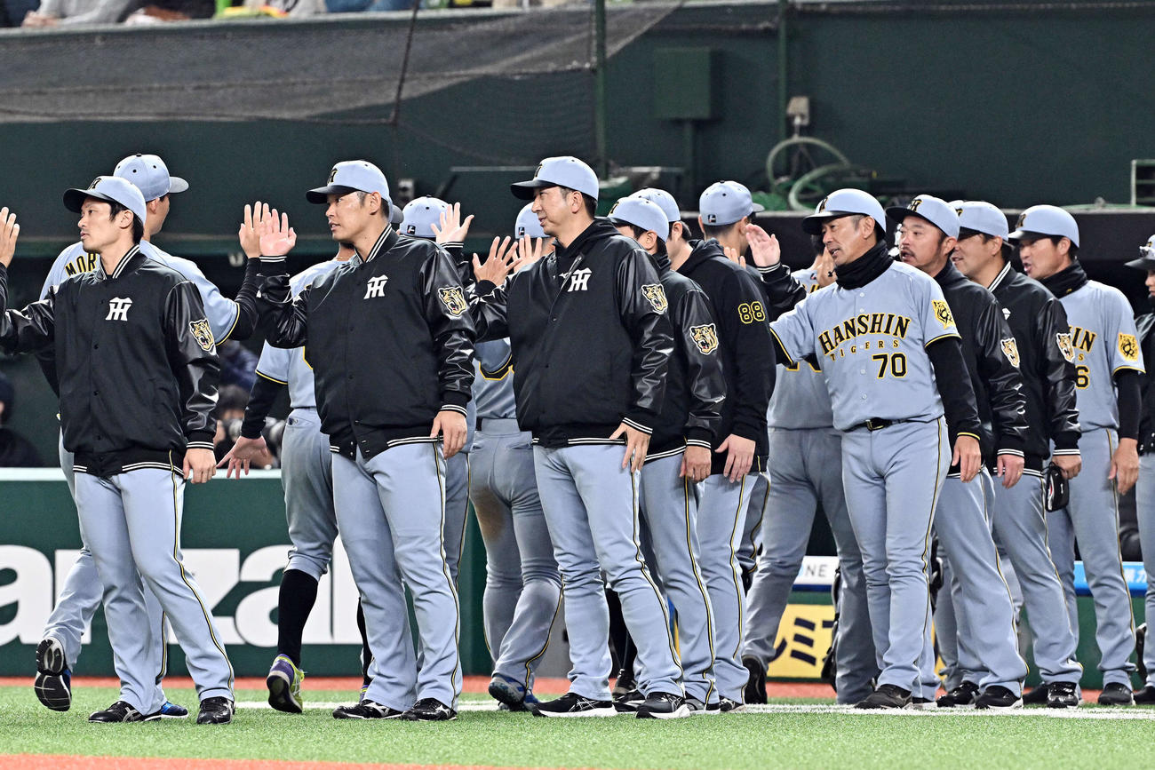 西武対阪神　勝利を飾り選手を迎える阪神藤川監督（前列左から3人目）（撮影・滝沢徹郎）
