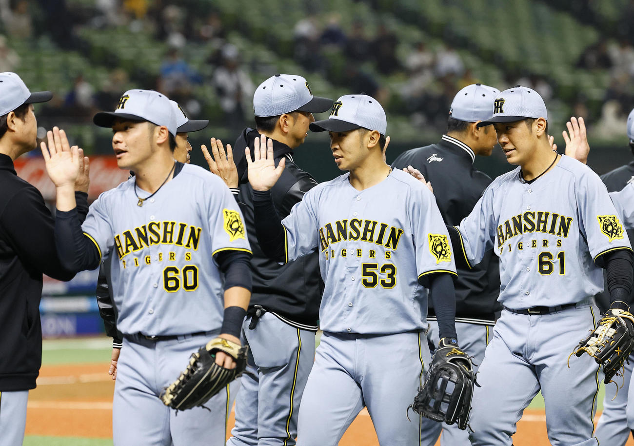 西武対阪神　西武に勝利し、タッチを交わす阪神島田（中央）ら（撮影・藤尾明華）