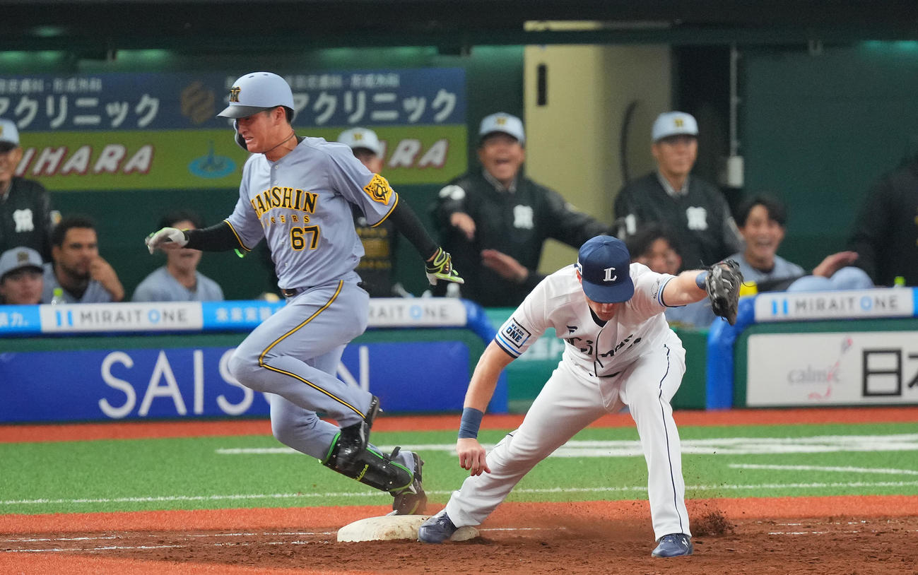 西武対阪神　5回表阪神2死三塁、適時内野安打を放つ高寺。一塁手ネビン（撮影・垰建太）