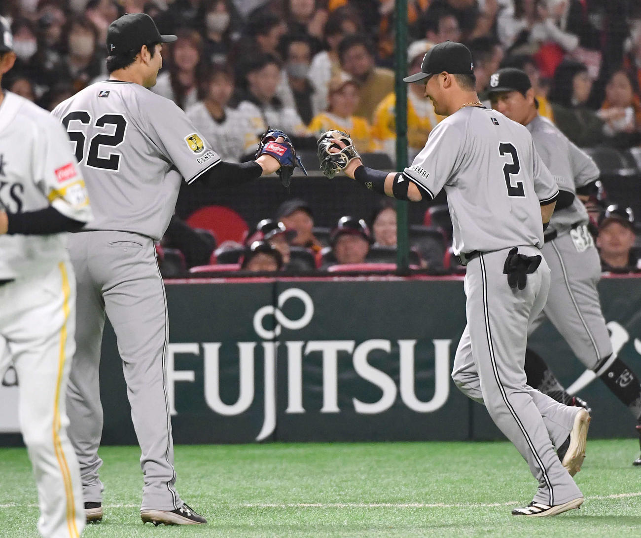ソフトバンク対巨人　1回裏を終え、好守を見せた吉川（右）とグラブタッチする横川（撮影・岩下翔太）