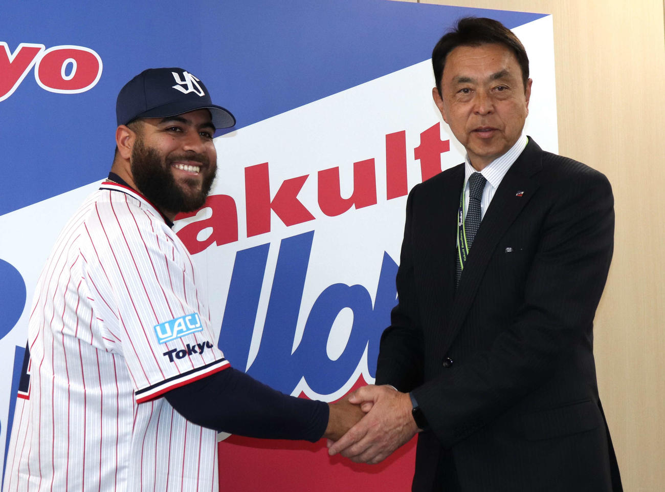 都内で行われたヤクルト入団会見に臨み笑顔で握手するアビラ（左）と小川GM（撮影・佐瀬百合子）