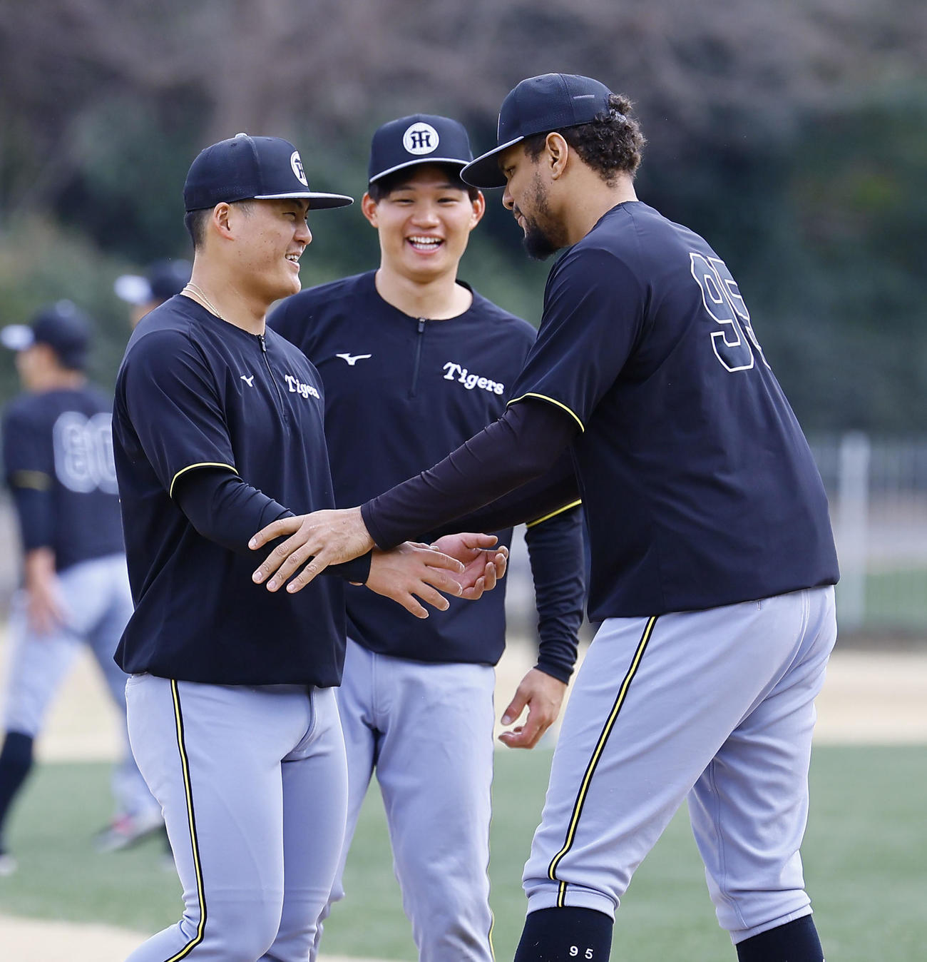 練習の合間にじゃれ合う阪神前川（左）とヘルナンデス（右）。中央は森下（撮影・藤尾明華）