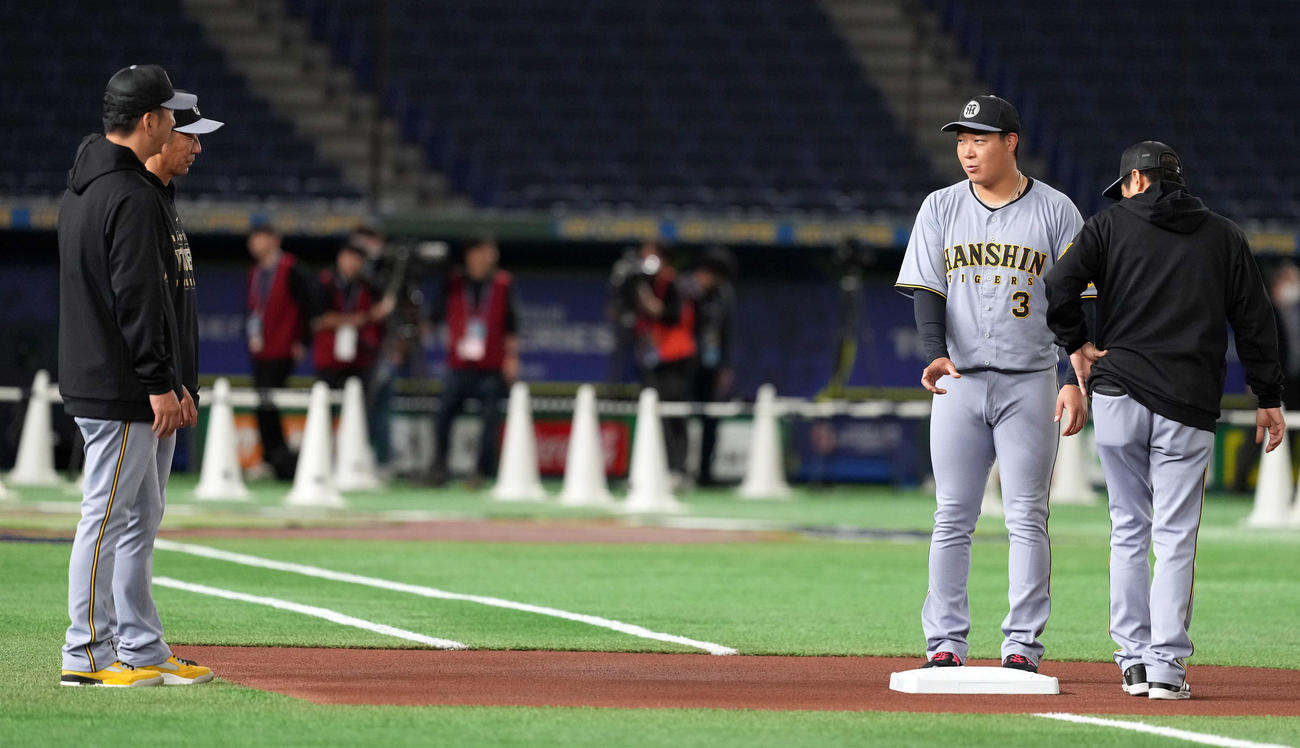 一塁ベースが大きい事を藤川監督（左）と話をする阪神大山（撮影・たえ見朱実）