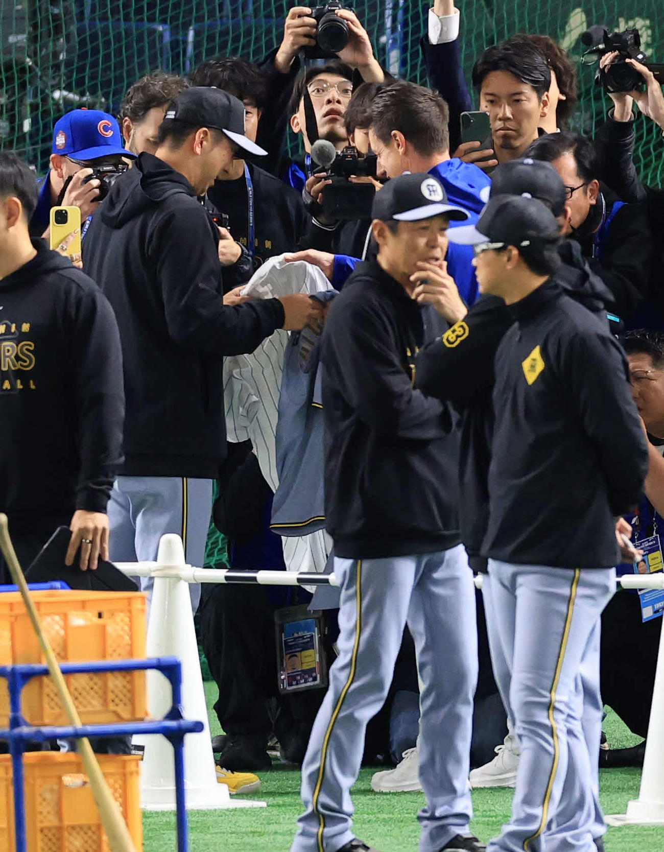 阪神対カブス　試合前練習中、ユニホームの交換をする阪神藤川監督（左）とカブスのカウンセル監督（撮影・浅見桂子）