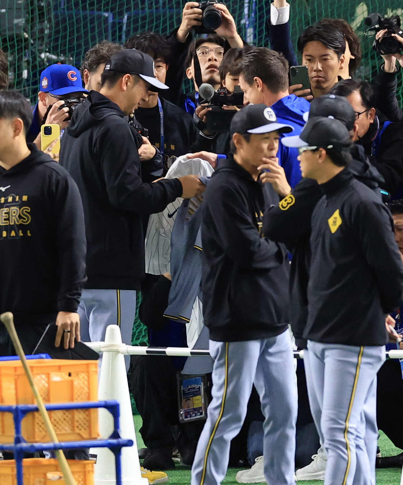 阪神対カブス　試合前練習中、ユニホームの交換をする阪神藤川監督（左）とカブスのカウンセル監督（撮影・浅見桂子）