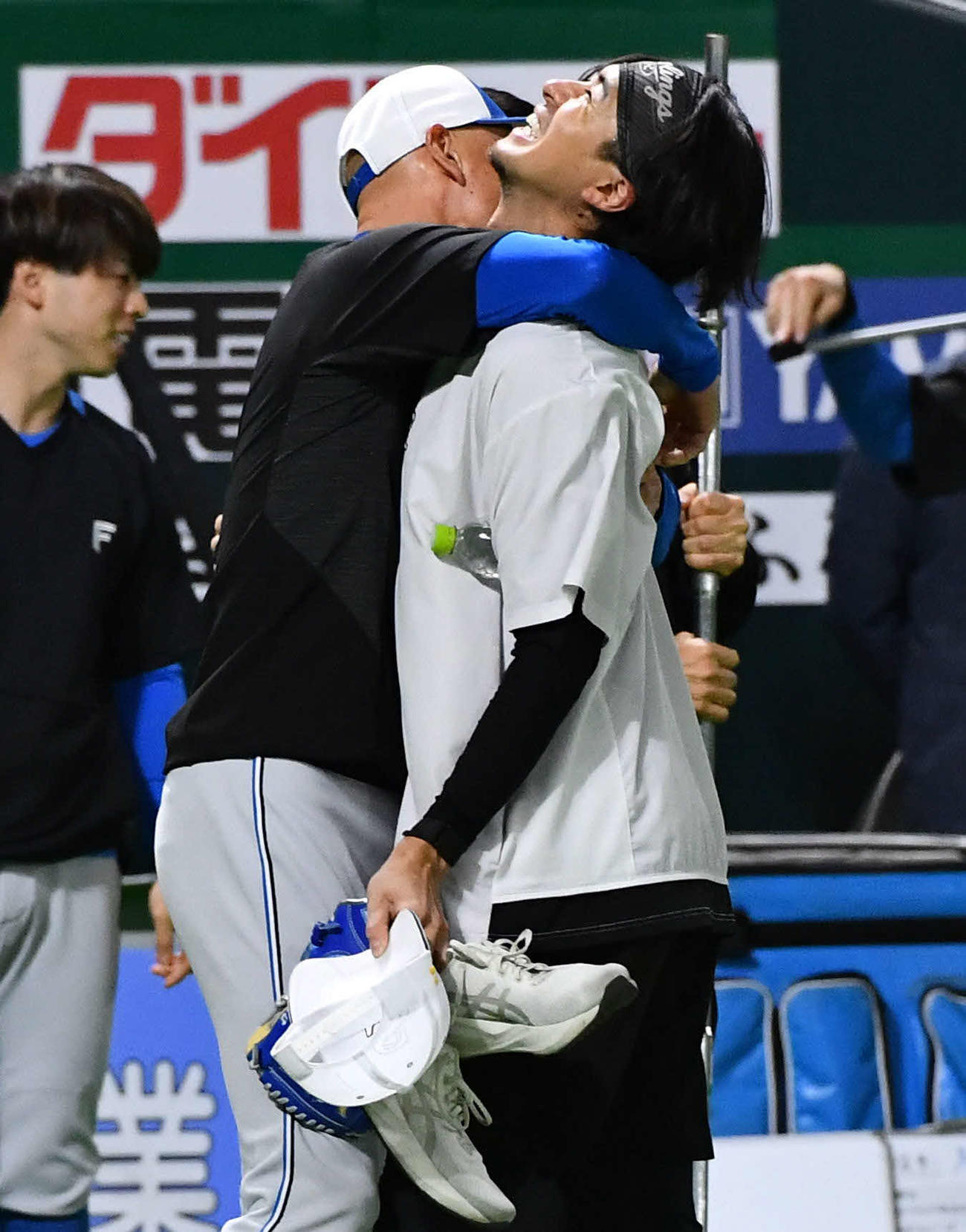 ソフトバンク対日本ハム　試合前、日本ハム森本コーチ（左）に抱きつかれて笑顔を見せるソフトバンク上沢（撮影・岩下翔太）