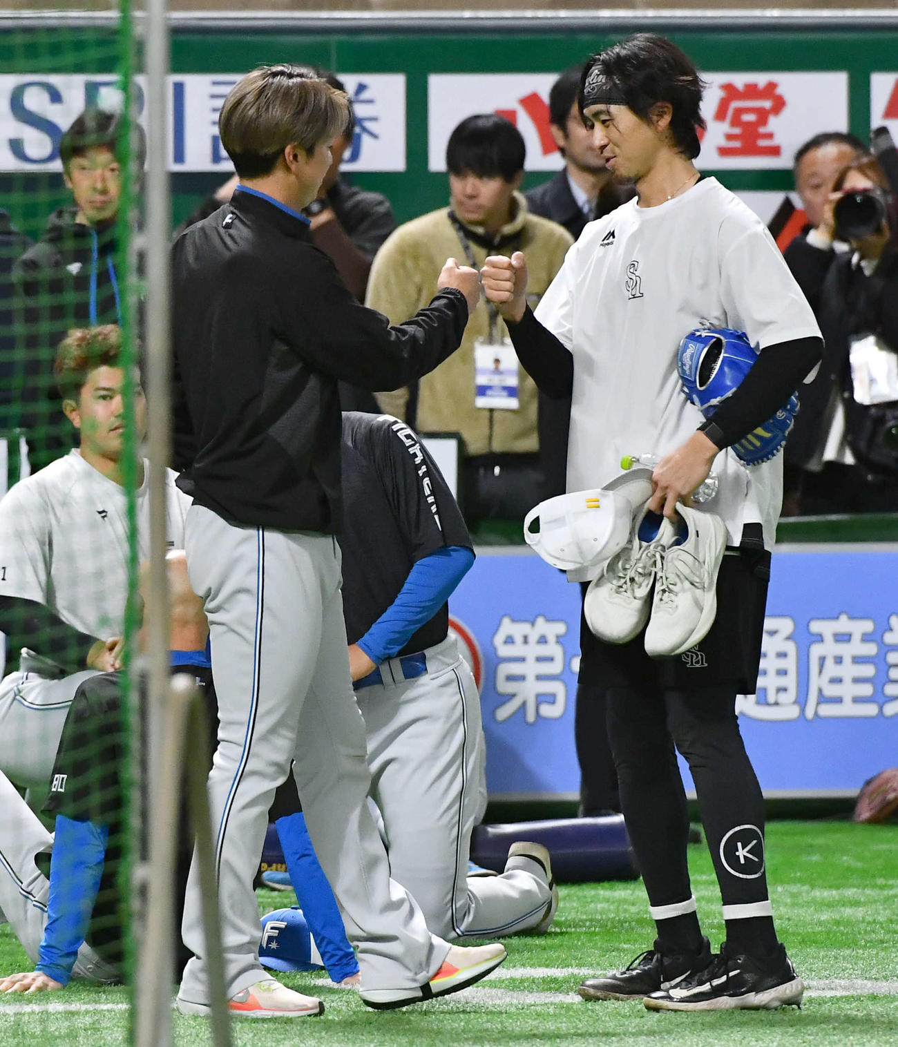 ソフトバンク対日本ハム　試合前、日本ハム松本剛（左）とグータッチを交わすソフトバンク上沢（撮影・岩下翔太）