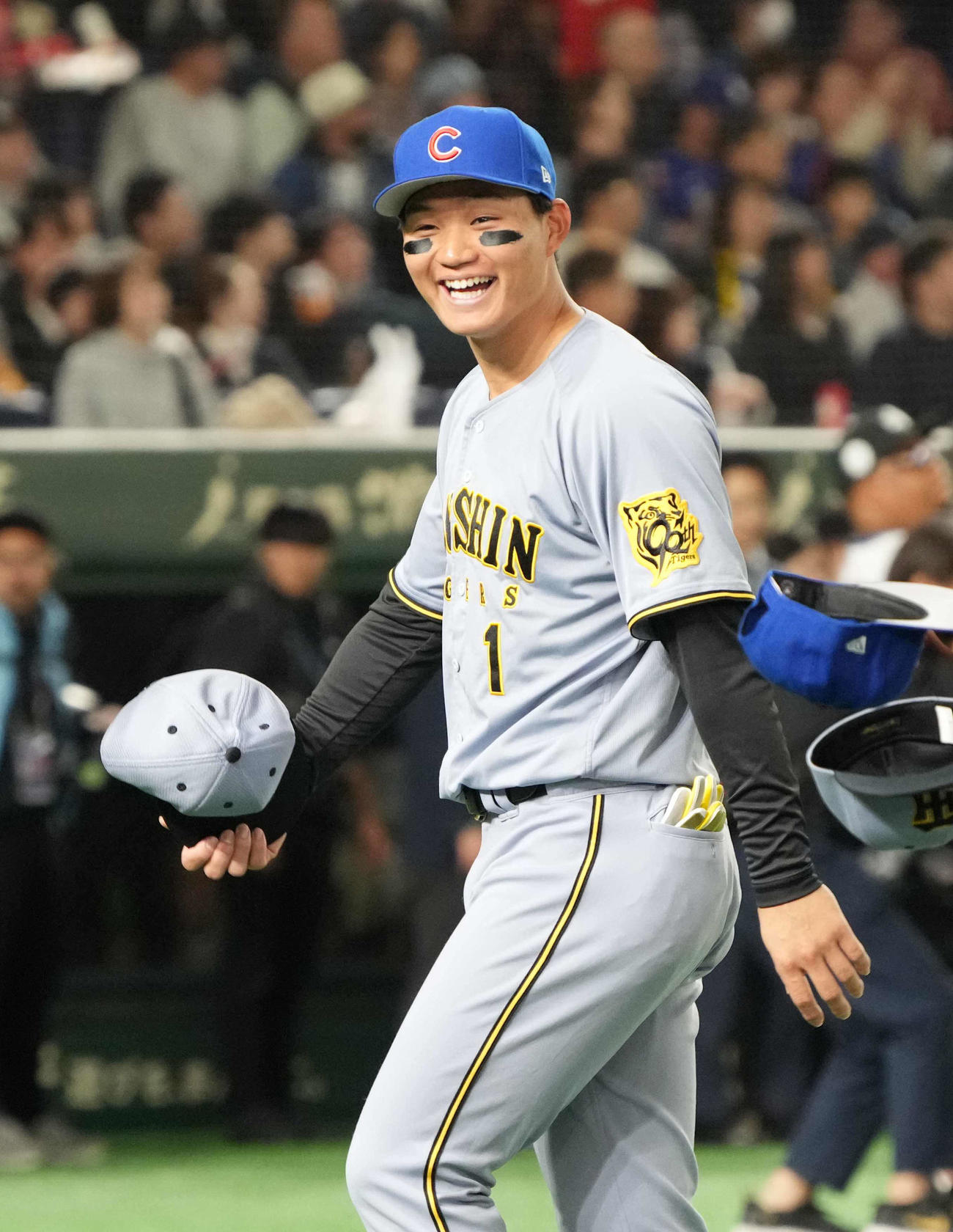 阪神対カブス　試合前のセレモニーで交換したカブスの帽子をうれしそうに被る阪神森下（撮影・小沢裕）